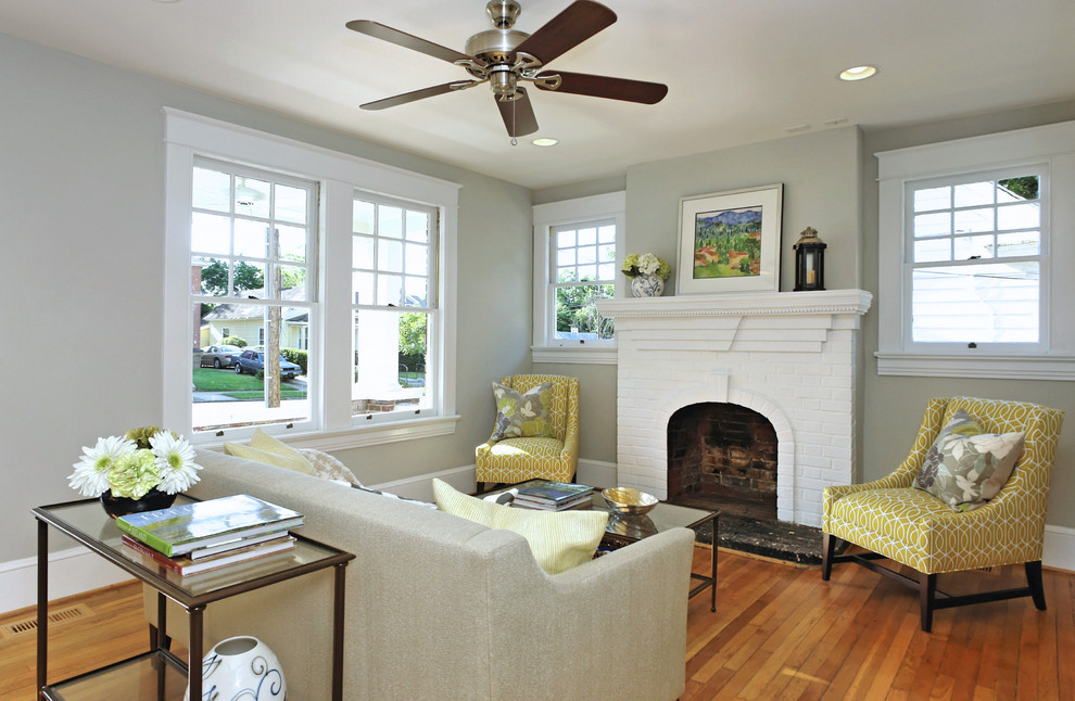Photo of a mid-sized traditional living room in Raleigh with grey walls, a standard fireplace and a brick fireplace surround.
