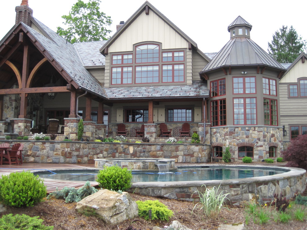 Large arts and crafts backyard round natural pool in Newark with a hot tub and natural stone pavers.