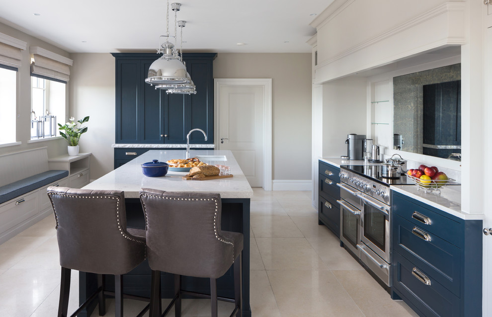 Inspiration for a transitional galley kitchen in Dublin with an undermount sink, shaker cabinets, blue cabinets, stainless steel appliances, with island, white floor, quartzite benchtops, metallic splashback, glass sheet splashback and limestone floors.