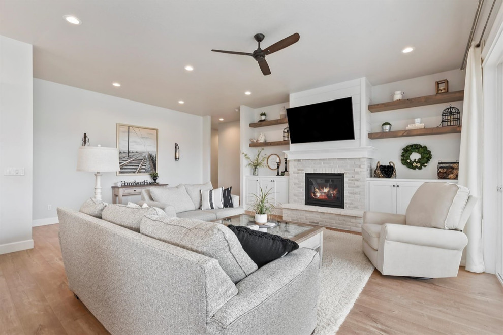 Example of a mid-sized classic open concept laminate floor and brown floor family room design in Boise with gray walls, a standard fireplace, a brick fireplace and a wall-mounted tv