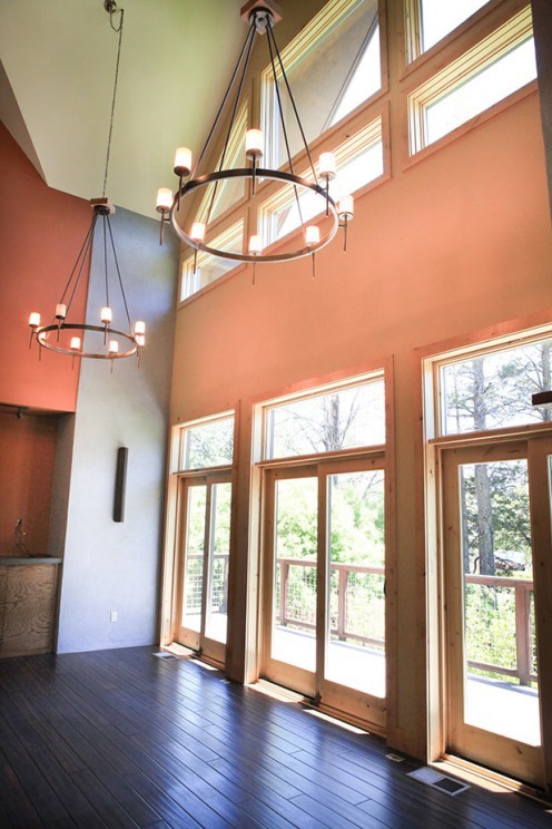 Example of a mid-sized mountain style dark wood floor and brown floor entry hall design with orange walls and a light wood front door