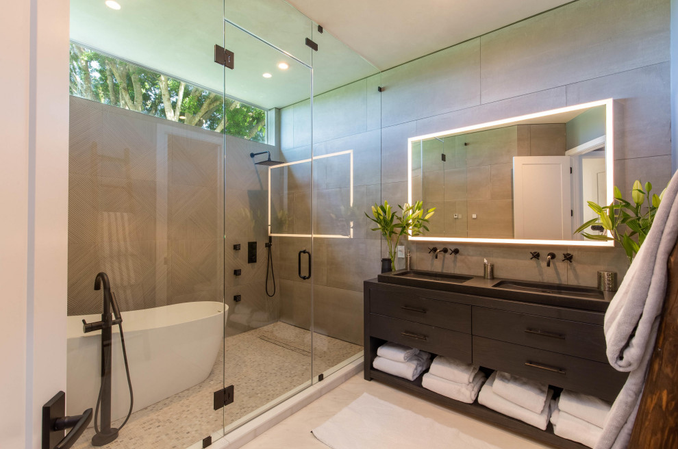 Medium sized contemporary ensuite wet room bathroom in Miami with flat-panel cabinets, black cabinets, a freestanding bath, grey tiles, concrete worktops, black worktops, double sinks, a freestanding vanity unit, porcelain tiles, mosaic tile flooring, white floors and an enclosed toilet.