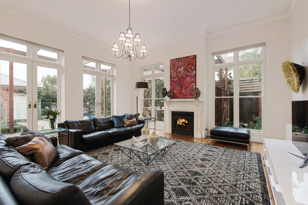 Design ideas for a large transitional open concept family room in Melbourne with white walls, light hardwood floors, a freestanding tv and a standard fireplace.