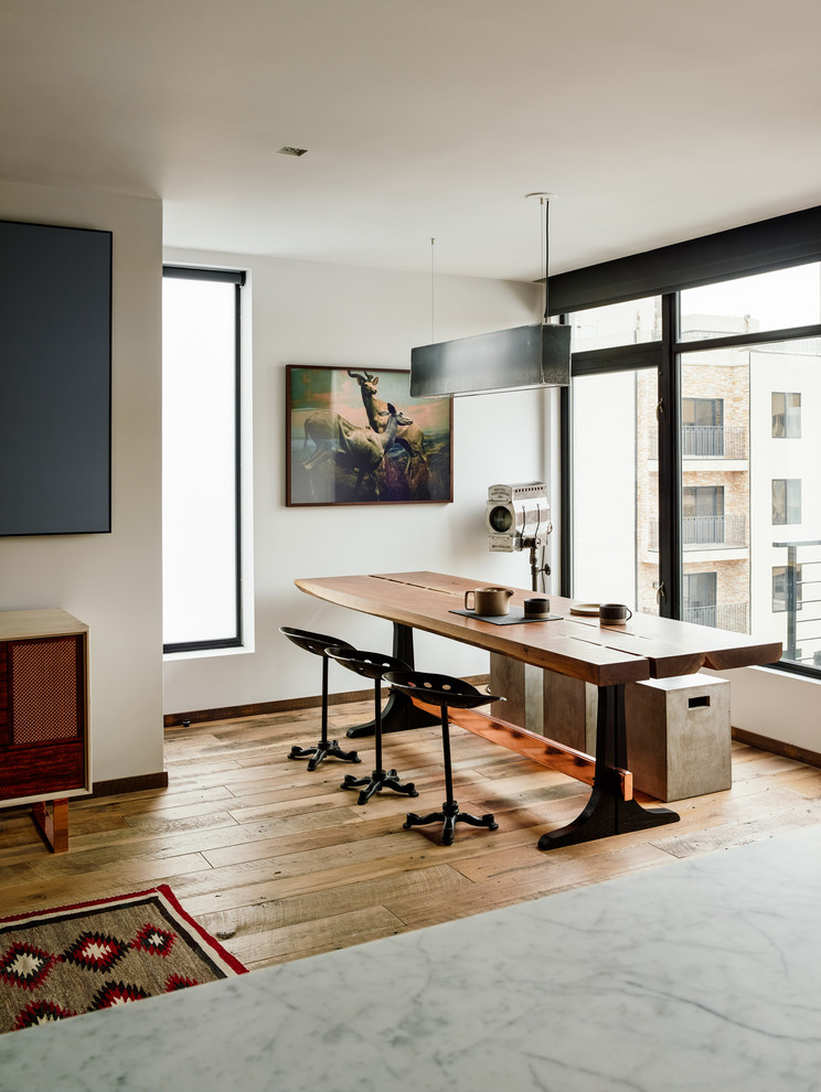 Photo of a mid-sized industrial open plan dining in New York with medium hardwood floors, white walls and no fireplace.