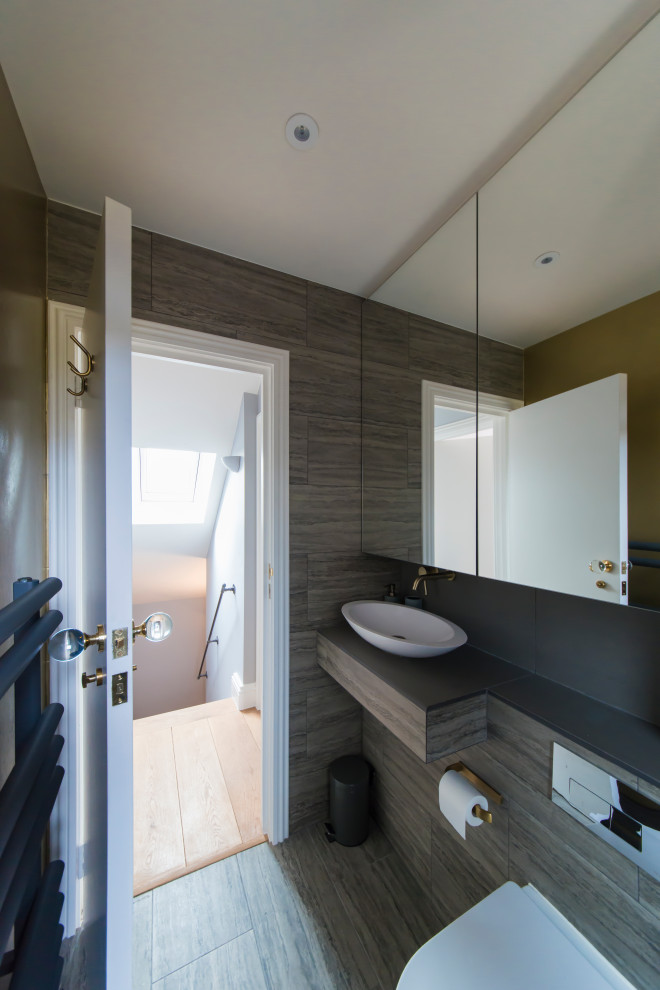 Design ideas for a small eclectic 3/4 bathroom in London with an open shower, a wall-mount toilet, gray tile, ceramic tile, grey walls, ceramic floors, grey floor, a sliding shower screen and grey benchtops.