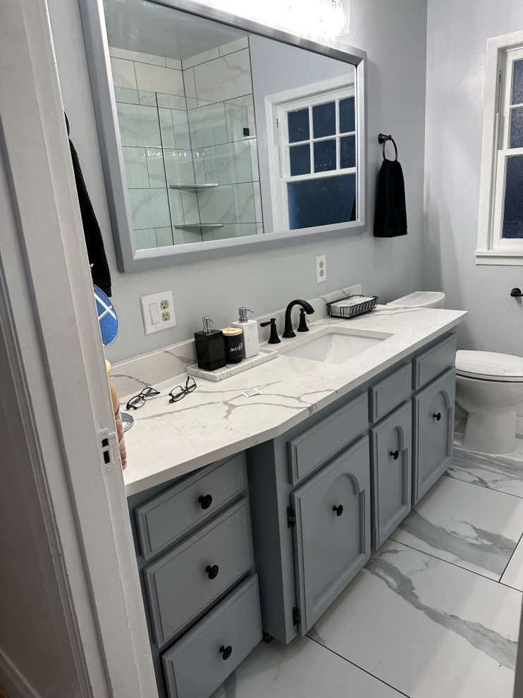 Пример оригинального дизайна: маленькая ванная комната в стиле модернизм с фасадами в стиле шейкер, серыми фасадами, накладной ванной, унитазом-моноблоком, белой плиткой, керамической плиткой, серыми стенами, полом из керамической плитки, врезной раковиной, столешницей из искусственного кварца, серым полом, белой столешницей, тумбой под одну раковину и встроенной тумбой для на участке и в саду