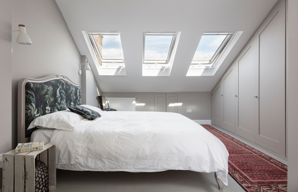 Mid-sized contemporary guest bedroom in London with grey walls, carpet and grey floor.