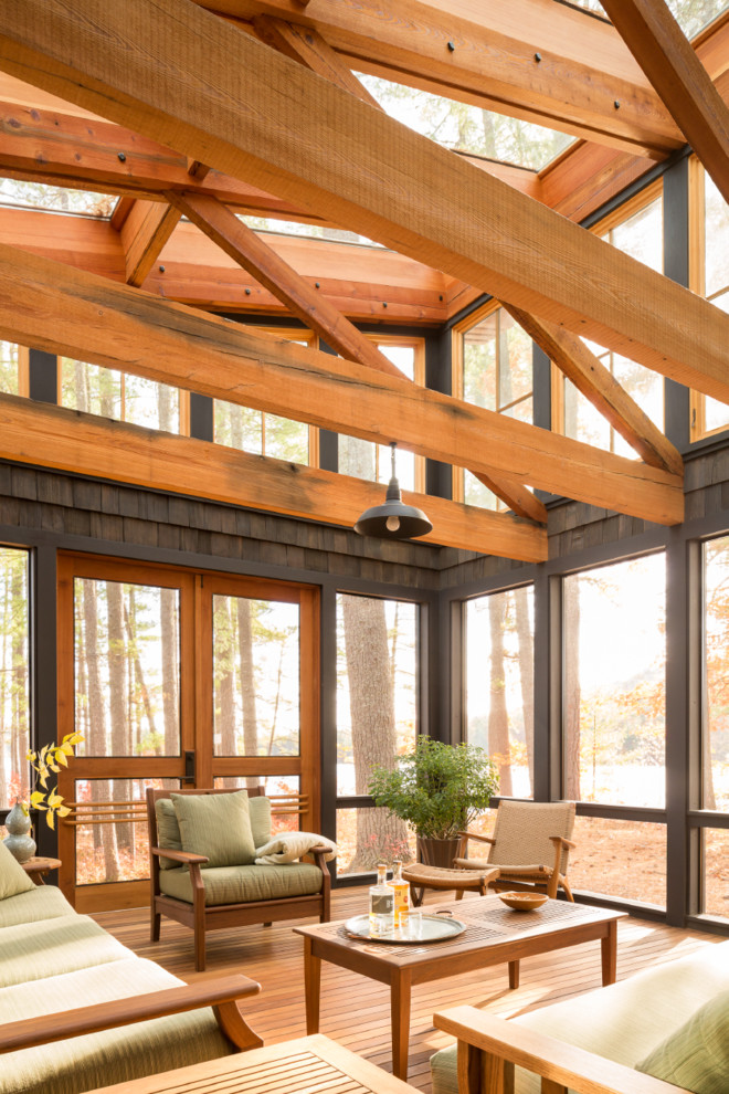 Design ideas for a mid-sized country backyard screened-in verandah in Portland Maine with a roof extension.