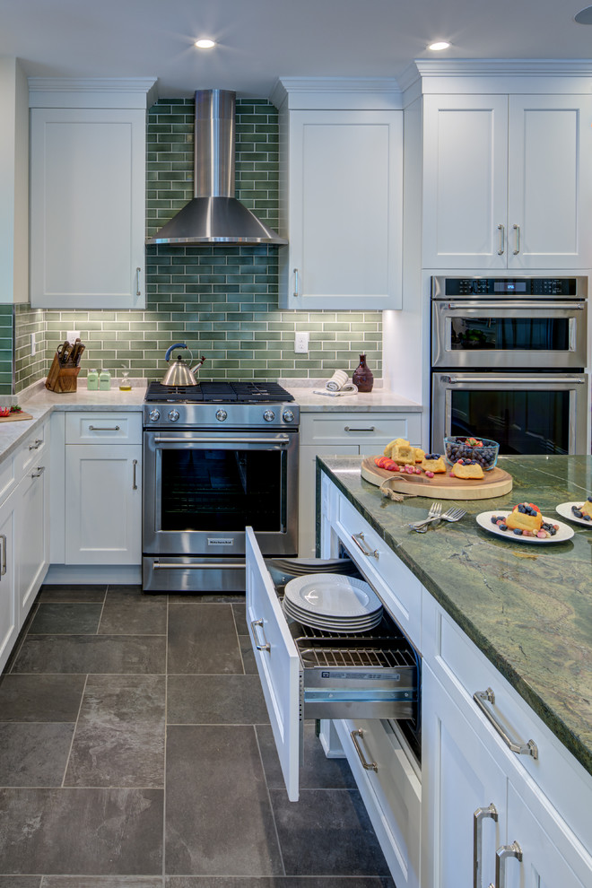 This is an example of a large transitional u-shaped open plan kitchen in DC Metro with an undermount sink, shaker cabinets, white cabinets, marble benchtops, green splashback, subway tile splashback, stainless steel appliances, slate floors, with island, black floor and green benchtop.