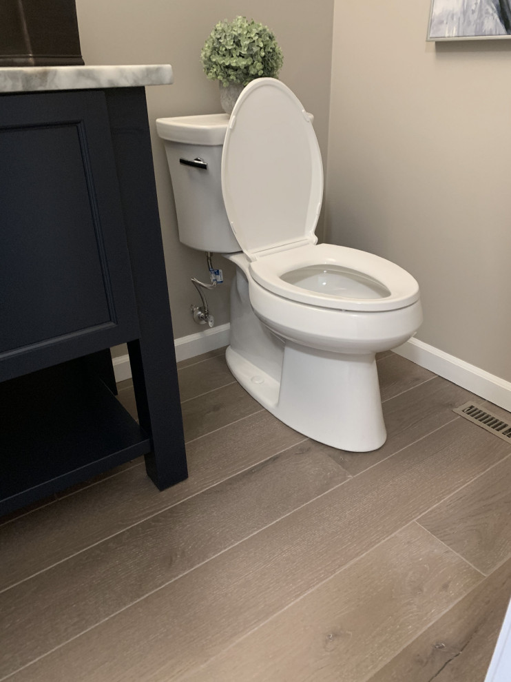 Inspiration for a small transitional vinyl floor and gray floor bathroom remodel with furniture-like cabinets, blue cabinets, a two-piece toilet, gray walls, an undermount sink, quartz countertops and multicolored countertops