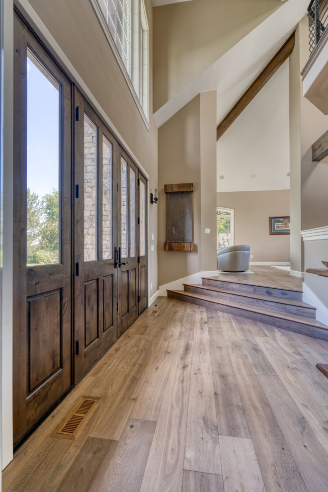 Haustür mit beiger Wandfarbe, hellem Holzboden, Doppeltür und freigelegten Dachbalken in Los Angeles