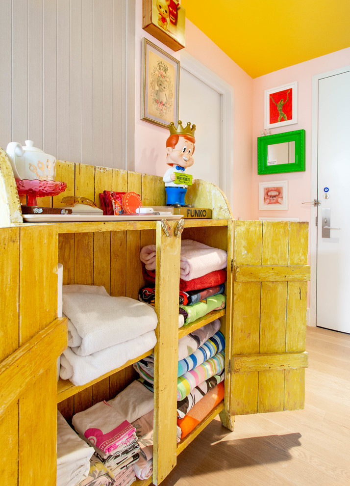 This is an example of a mid-sized eclectic kids' room for girls in New York with pink walls.