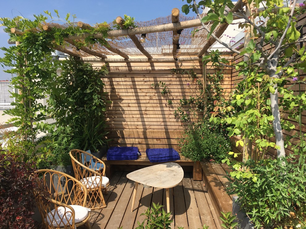 Photo of a large beach style rooftop and rooftop deck in Paris with a container garden and a pergola.