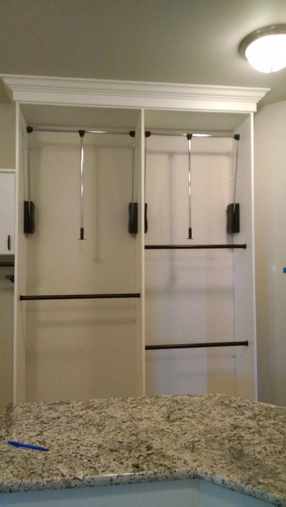 Photo of a mid-sized modern gender-neutral walk-in wardrobe in Denver with open cabinets, white cabinets and carpet.