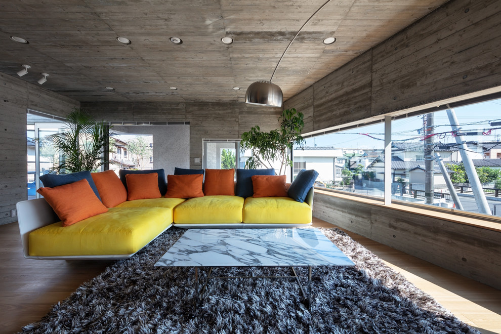 Photo of a modern open concept living room with grey walls, light hardwood floors and beige floor.