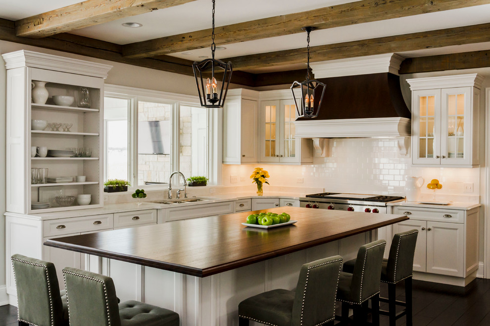 Example of a large transitional l-shaped dark wood floor eat-in kitchen design in Chicago with an undermount sink, recessed-panel cabinets, white cabinets, quartz countertops, white backsplash, ceramic backsplash, stainless steel appliances and an island