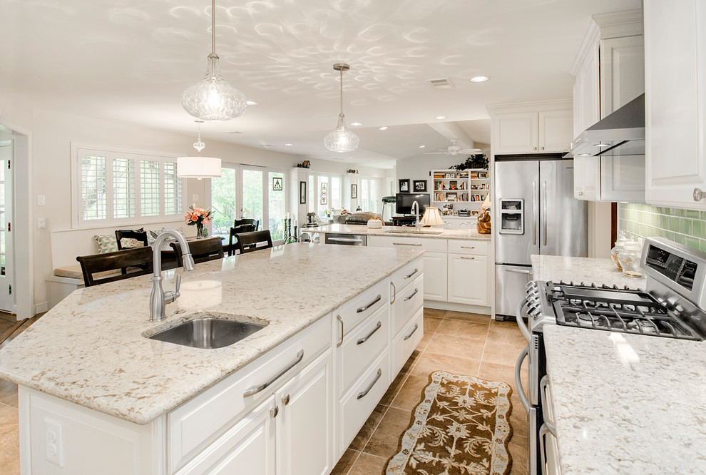 Photo of a large traditional eat-in kitchen in Dallas with a double-bowl sink, raised-panel cabinets, white cabinets, quartz benchtops, green splashback, ceramic splashback, stainless steel appliances, porcelain floors and with island.