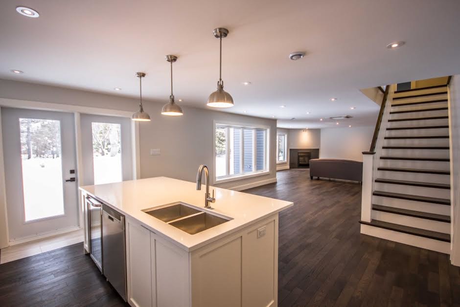 Example of a mid-sized transitional single-wall dark wood floor home design design with an undermount sink, shaker cabinets, white cabinets, quartzite countertops, stainless steel appliances and an island