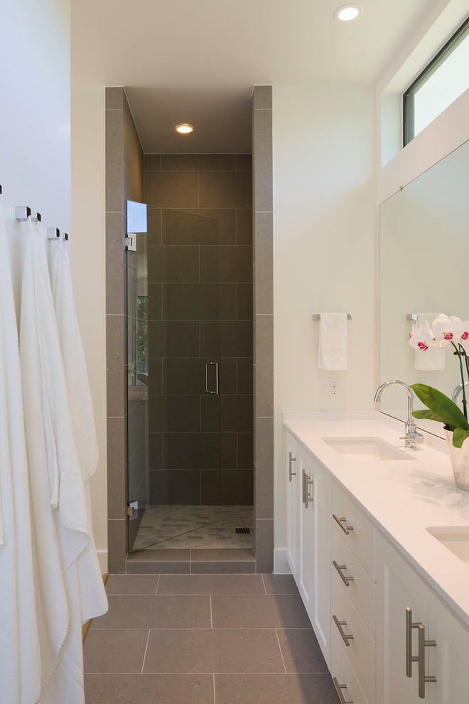 Inspiration for a mid-sized contemporary master bathroom in Austin with an alcove shower, shaker cabinets, white cabinets, a two-piece toilet, white tile, white walls, cement tiles, a drop-in sink, solid surface benchtops, brown floor and a hinged shower door.