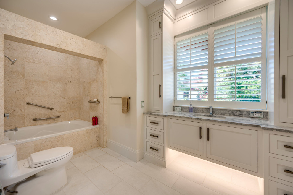 Inspiration for a transitional kids' beige tile and travertine tile porcelain tile, beige floor and single-sink alcove bathtub remodel with beaded inset cabinets, white cabinets, a one-piece toilet, beige walls, an undermount sink, quartz countertops, gray countertops and a floating vanity