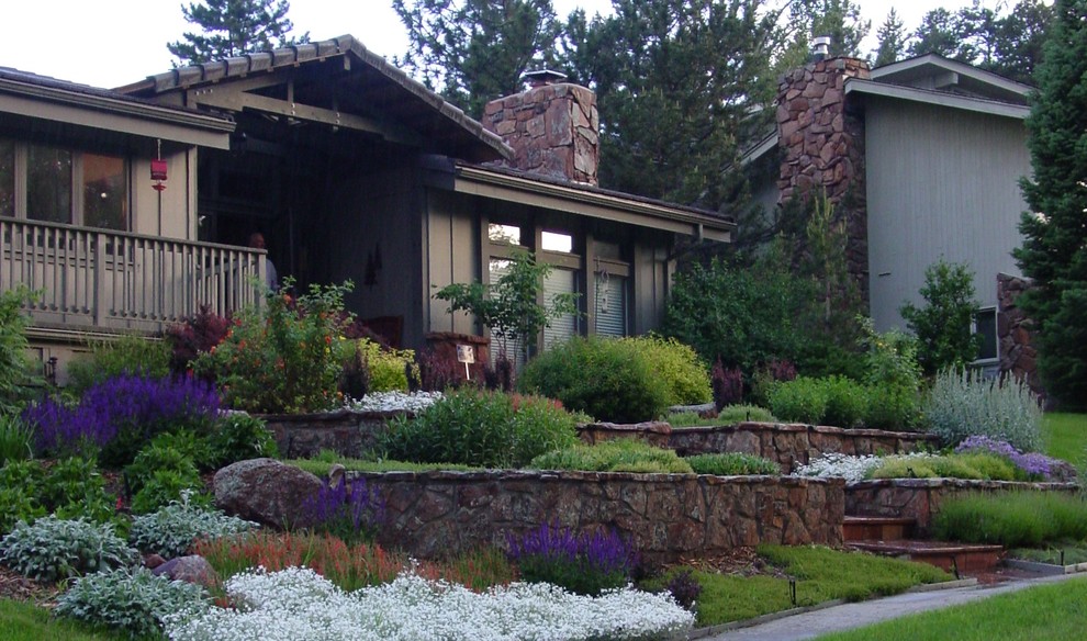 This is an example of a large traditional front yard stone retaining wall landscape in Denver.