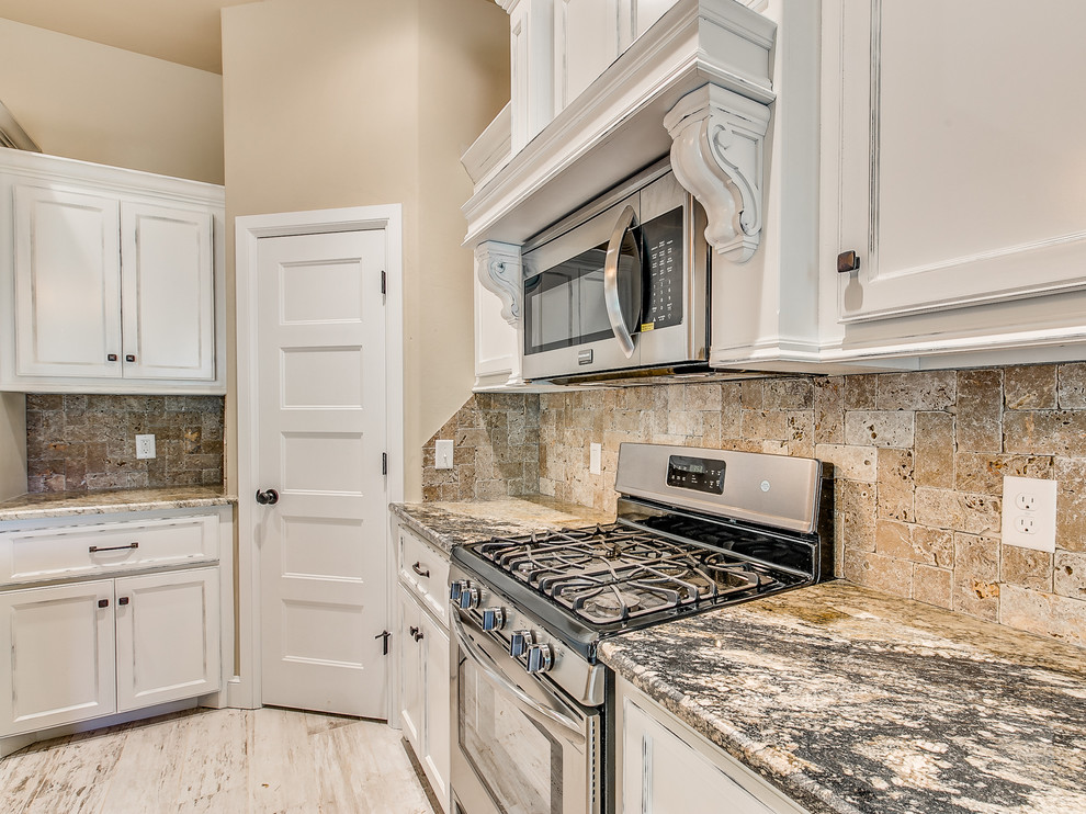 Inspiration for a traditional l-shaped eat-in kitchen in Oklahoma City with an undermount sink, recessed-panel cabinets, distressed cabinets, granite benchtops, multi-coloured splashback, stone tile splashback, stainless steel appliances, ceramic floors and with island.