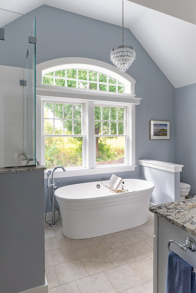 Inspiration for a large transitional master bathroom in Boston with grey cabinets, a freestanding tub, ceramic floors, granite benchtops, beige floor, multi-coloured benchtops, a two-piece toilet, white tile, ceramic tile, blue walls and an undermount sink.