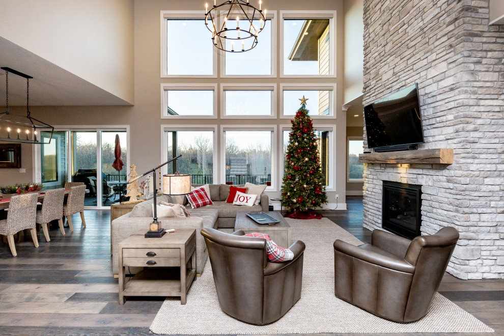 Large transitional open concept vinyl floor and brown floor living room photo with gray walls, a standard fireplace, a stone fireplace and a wall-mounted tv