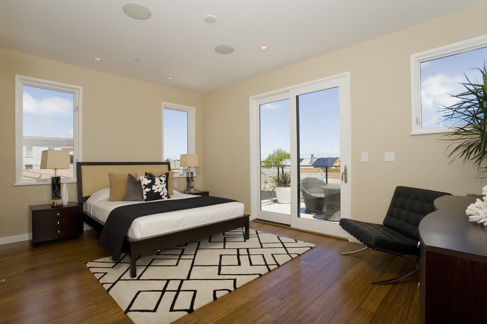 This is an example of a contemporary bedroom in San Francisco with beige walls and dark hardwood floors.