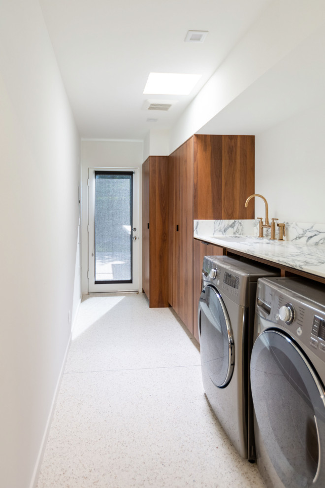 Inspiration for a mid-sized midcentury single-wall dedicated laundry room in Other with an undermount sink, flat-panel cabinets, dark wood cabinets, quartz benchtops, white splashback, engineered quartz splashback, white walls, a side-by-side washer and dryer, white floor and white benchtop.