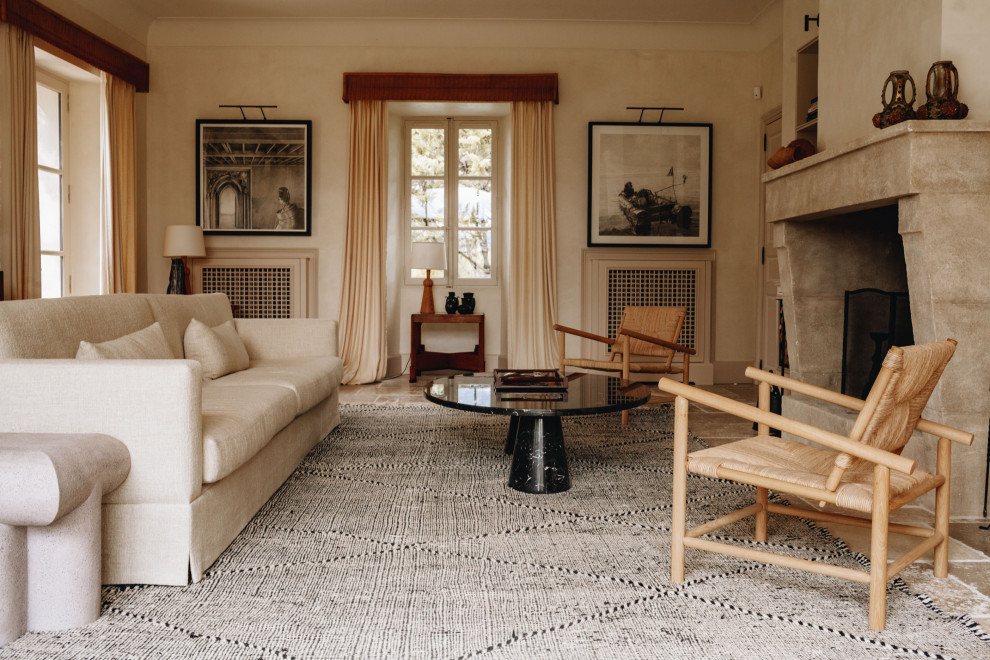 Inspiration pour un salon méditerranéen avec un mur beige, une cheminée standard et un sol beige.