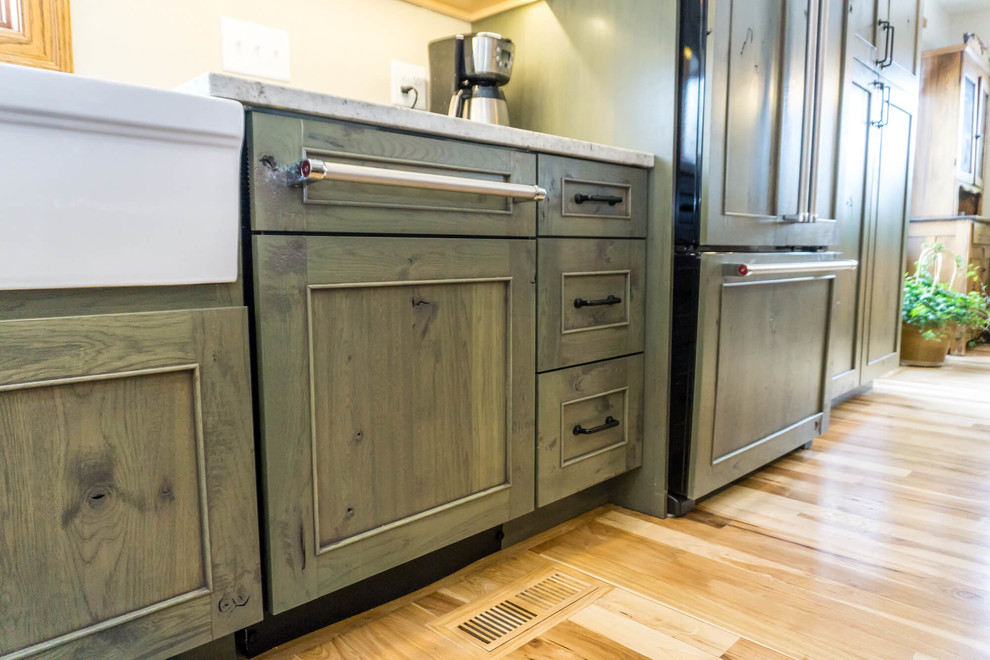 Open concept kitchen - large rustic light wood floor and brown floor open concept kitchen idea with beaded inset cabinets, distressed cabinets, granite countertops, an island and white countertops