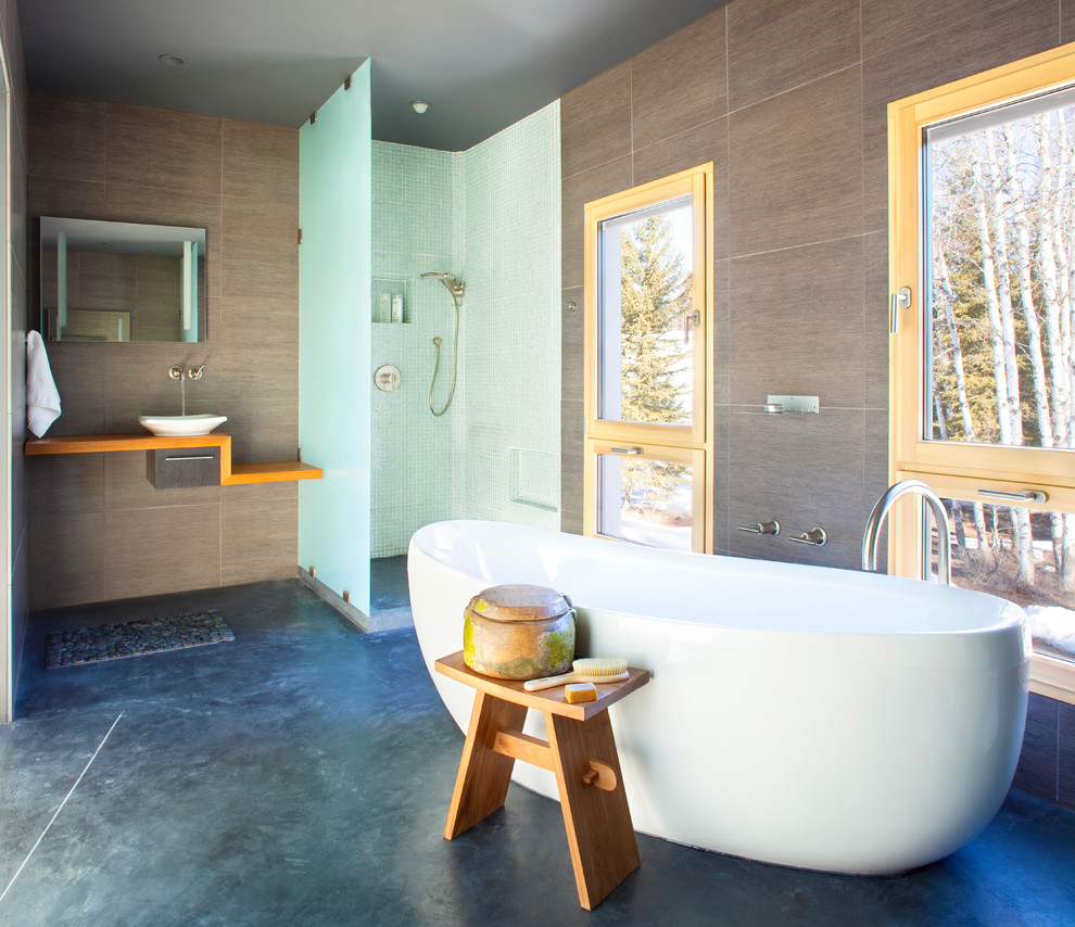 Contemporary bathroom in Other with a vessel sink, a freestanding tub, a corner shower and concrete floors.