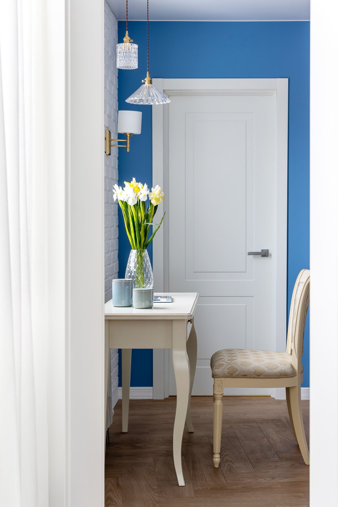 Exemple d'un salon blanc et bois chic de taille moyenne avec une salle de réception, un mur bleu, un sol en bois brun, aucun téléviseur, un sol beige et un mur en parement de brique.