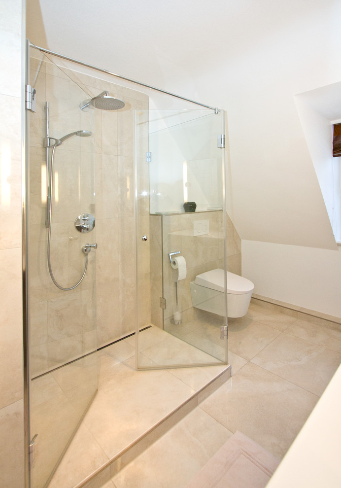 Inspiration for a mid-sized contemporary bathroom in Hamburg with a corner shower, a wall-mount toilet, beige tile, white walls, beige floor and a hinged shower door.