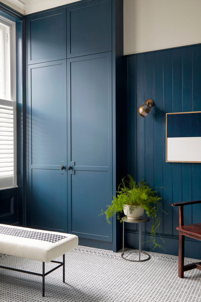 Foto på en mellanstor funkis garderob för könsneutrala, med skåp i shakerstil, blå skåp, klinkergolv i porslin och vitt golv