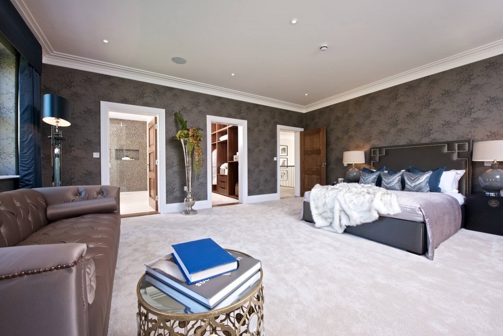 This is an example of an expansive contemporary master bedroom in Sussex with grey walls, carpet and no fireplace.