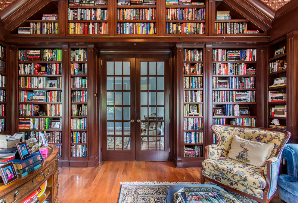 This is an example of a large traditional home office in New York with medium hardwood floors, no fireplace and a library.