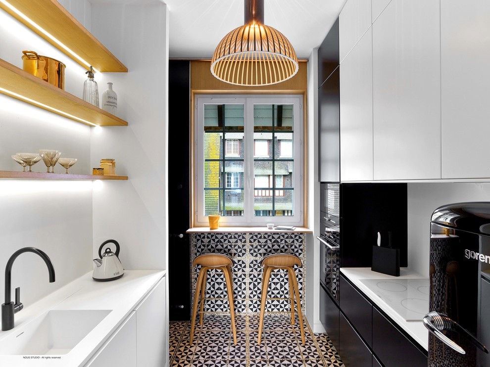 Small contemporary galley separate kitchen in Paris with a single-bowl sink, flat-panel cabinets, white cabinets, white splashback, ceramic splashback, white appliances, ceramic floors and no island.