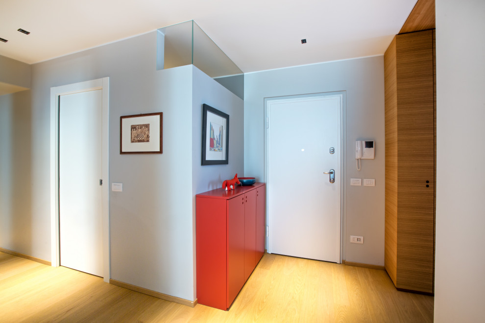 Стильный дизайн: коридор среднего размера в современном стиле с серыми стенами и деревянным полом - последний тренд