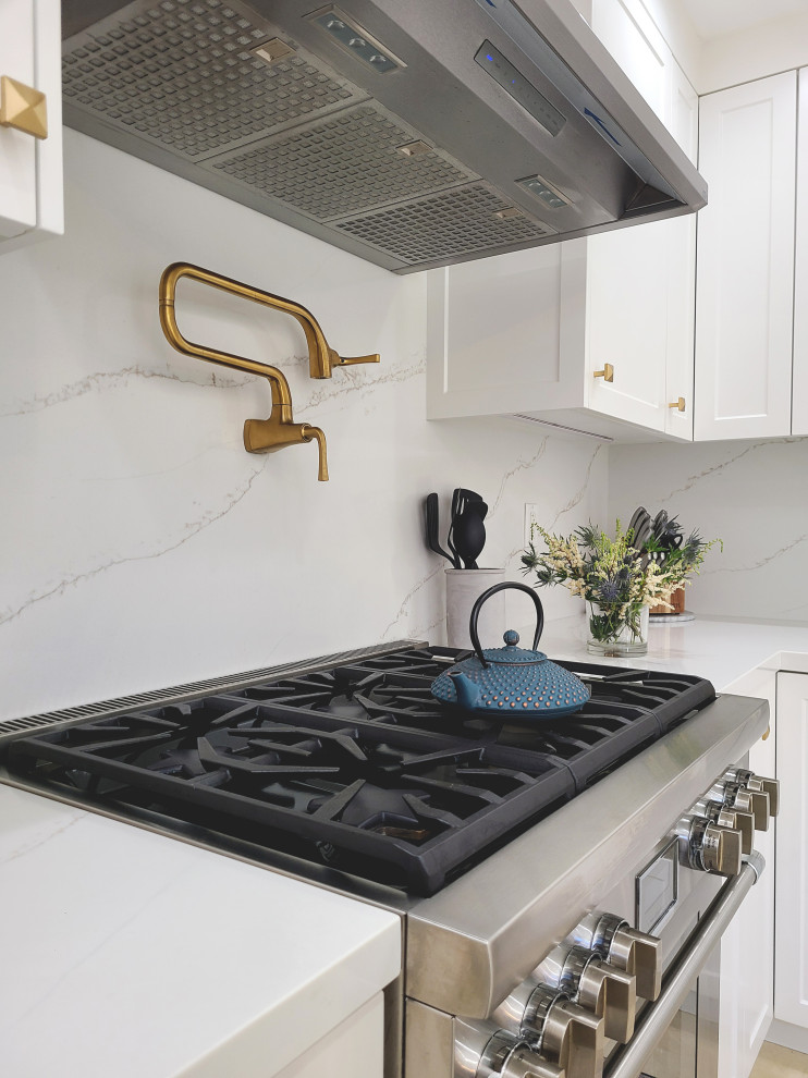 Example of a mid-sized transitional u-shaped enclosed kitchen design in Los Angeles with an undermount sink, shaker cabinets, white cabinets, quartz countertops, white backsplash, stainless steel appliances, no island and white countertops