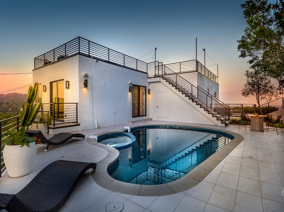 Mid-sized midcentury rooftop custom-shaped lap pool in Los Angeles with a hot tub.
