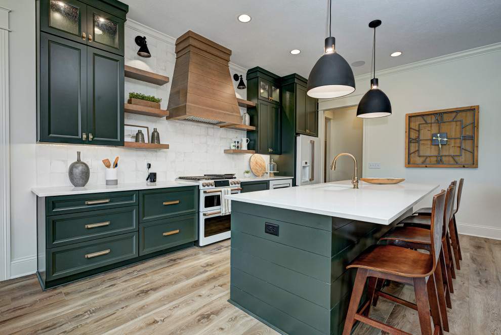 This is an example of a medium sized classic galley kitchen/diner in Indianapolis with a belfast sink, shaker cabinets, green cabinets, granite worktops, white splashback, ceramic splashback, white appliances, vinyl flooring, an island, brown floors and white worktops.