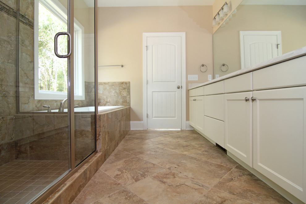 Mid-sized country master bathroom in Raleigh with an integrated sink, recessed-panel cabinets, white cabinets, solid surface benchtops, a corner tub, a one-piece toilet, beige tile, ceramic tile, beige walls and ceramic floors.