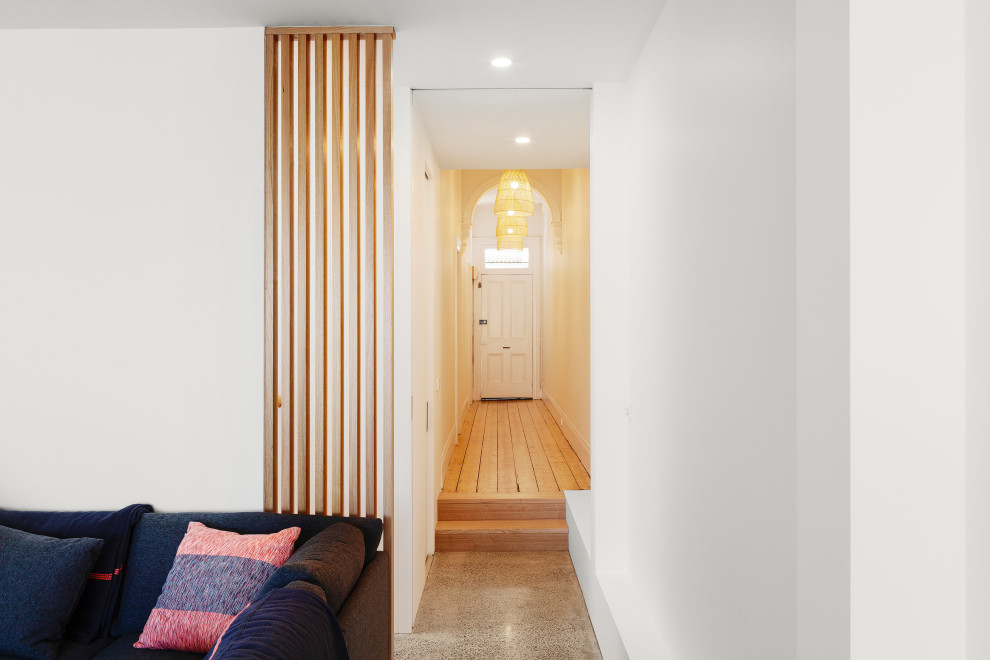 Small modern hallway in Melbourne with white walls, concrete floors and grey floor.
