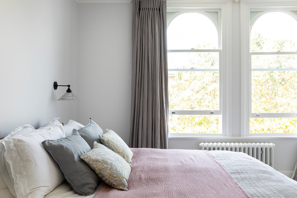 Transitional master bedroom in London with grey walls and carpet.