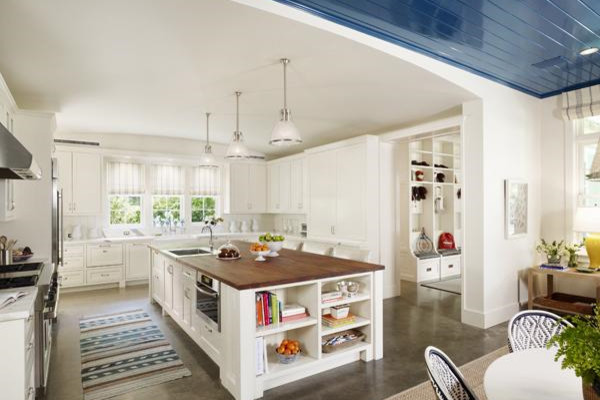 Inspiration for a mid-sized transitional u-shaped eat-in kitchen in Houston with a drop-in sink, recessed-panel cabinets, white cabinets, wood benchtops, white splashback, subway tile splashback, stainless steel appliances, concrete floors, with island and grey floor.