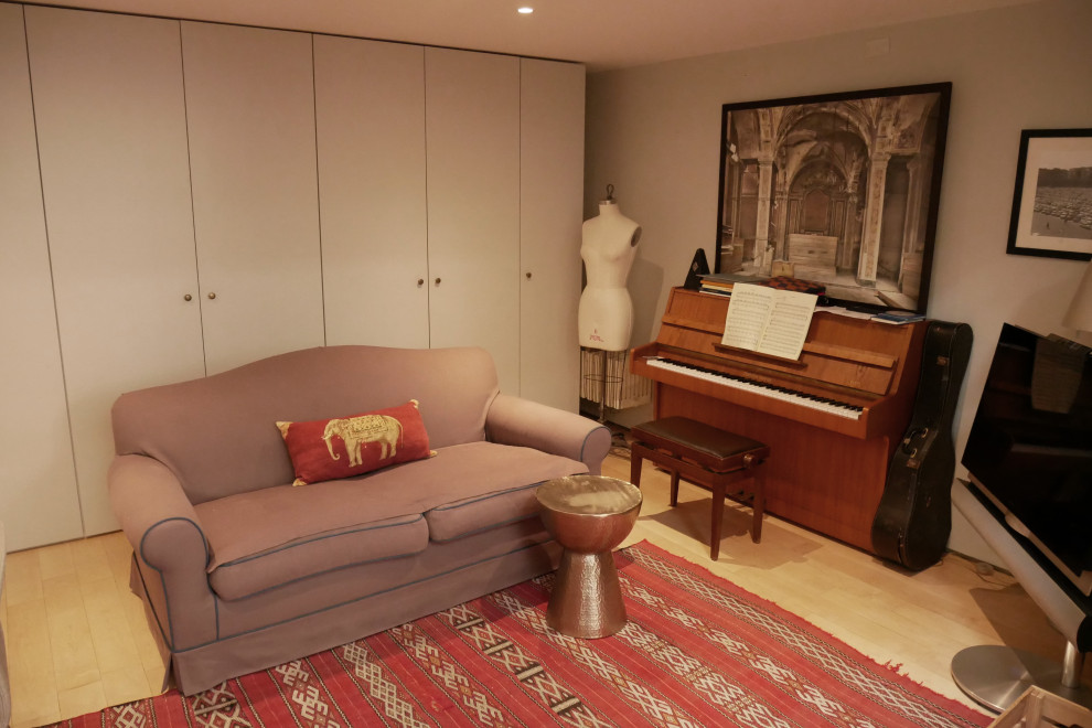Inredning av ett modernt mellanstort hemmastudio, med grå väggar, ljust trägolv och ett fristående skrivbord