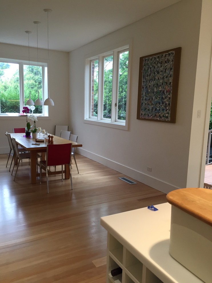 Mid-sized contemporary kitchen/dining combo in Sydney with beige walls and light hardwood floors.