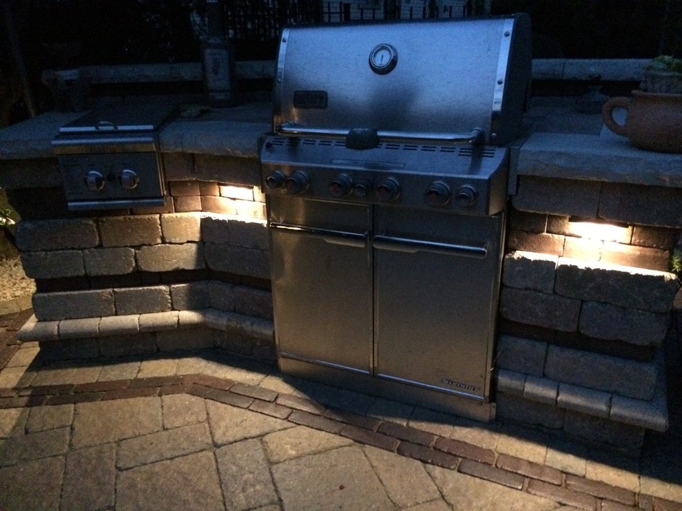 Inspiration for a mid-sized transitional backyard patio in Chicago with an outdoor kitchen, natural stone pavers and no cover.